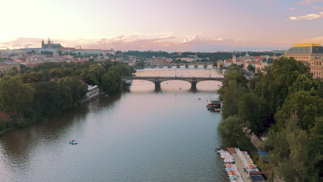 Prague Breathtaking aerial drone shot, flying over river, pink sunset Praha, Czech Republic