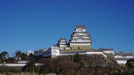 Himeji-Schloss-Mit-Klarem-Blauem-Himmelshintergrund,-Schwenkender-Herstellender-Schuss,-Japan