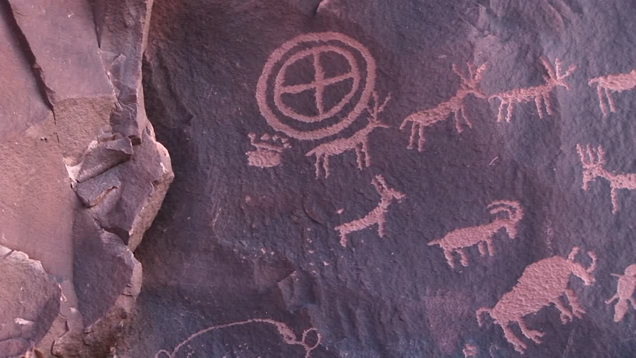 Medium shot of ancient American Indian petroglyphs at Newspaper Rock Utah