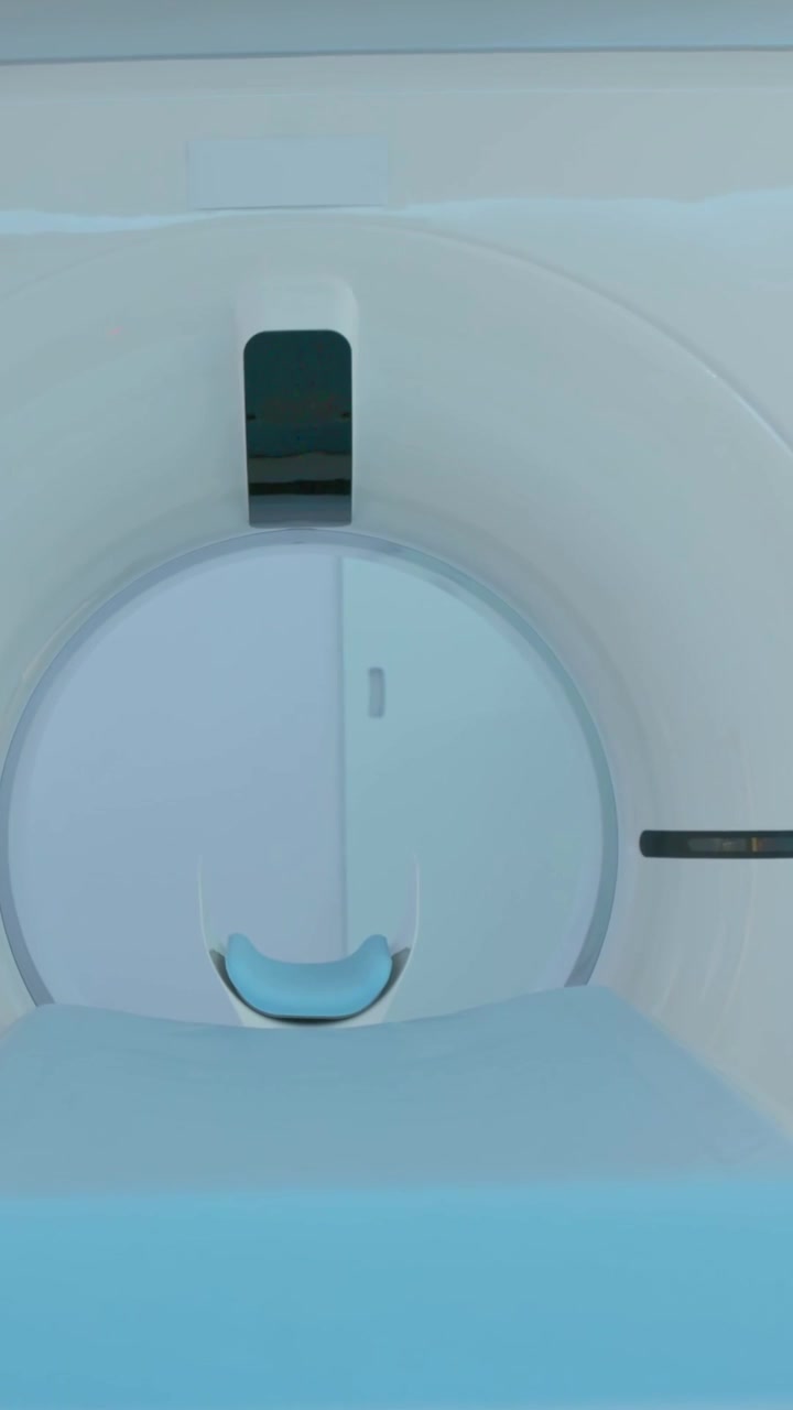 Video verticale: Lettino scorrevole che si muove nel gantry sotto controllo, con poggiatesta a U che si allinea per la scansione della testa