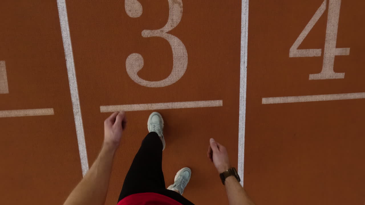 First-person view of an athlete training on an indoor track, including running and resistance sled pulls