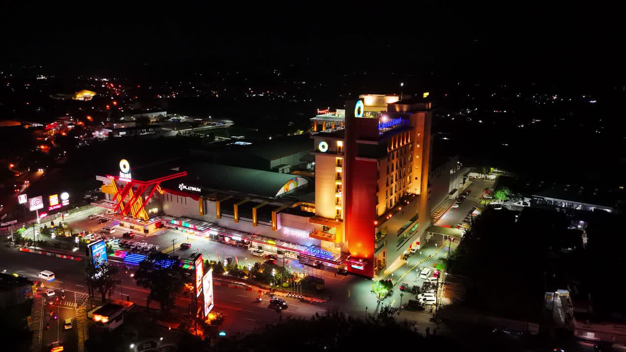 Aerial view of Atos Hotel and Mall in the night. Illuminated building with colorful lamp. 4K drone shot.