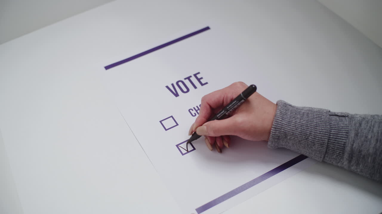 Close up of Female Voter Filling out Paper Ballot during Elections Close up of Female Voter Making Choice and Voting for Presidential Candidate or Political Party in Voting Booth Anonymous Woman Fills out Paper Ballot during Elections Civic Duty and Democracy