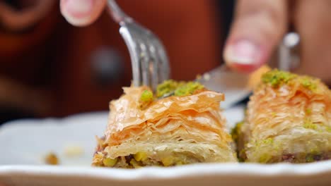 close up of someone eating baklava with a fork