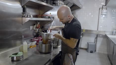 chef straining soup in a restaurant kitchen