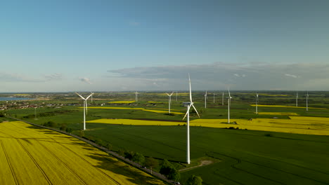 Turbinas-Eólicas-Proyectan-Largas-Sombras-Sobre-Los-Campos-Agrícolas-De-Lebcz-Polonia---Vista-Aérea-Cinematográfica