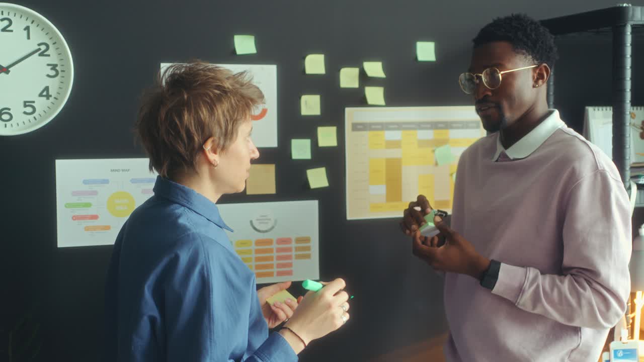 Two Colleagues Using Sticky Notes and Brainstorming in Office