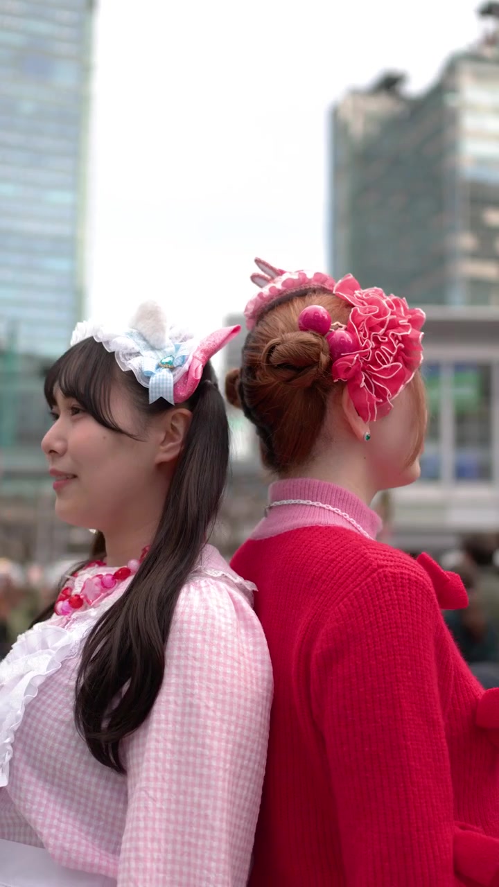 Ripresa ravvicinata in movimento di due donne che indossano vivaci abiti in stile Harajuku decora a Tokyo