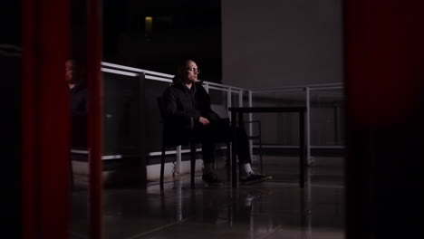 man sitting on a balcony at night