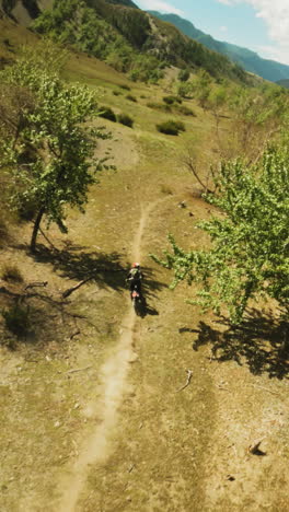 motociclista viaja en motocicleta a través de las tierras altas fpv. deportista disfruta de motocicleta extrema en la naturaleza salvaje en un día soleado desafío de ruta de motocross