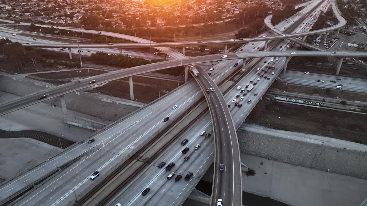 Aerial view rising in front of traffic on a elevated freeway in LA, sunset in USA