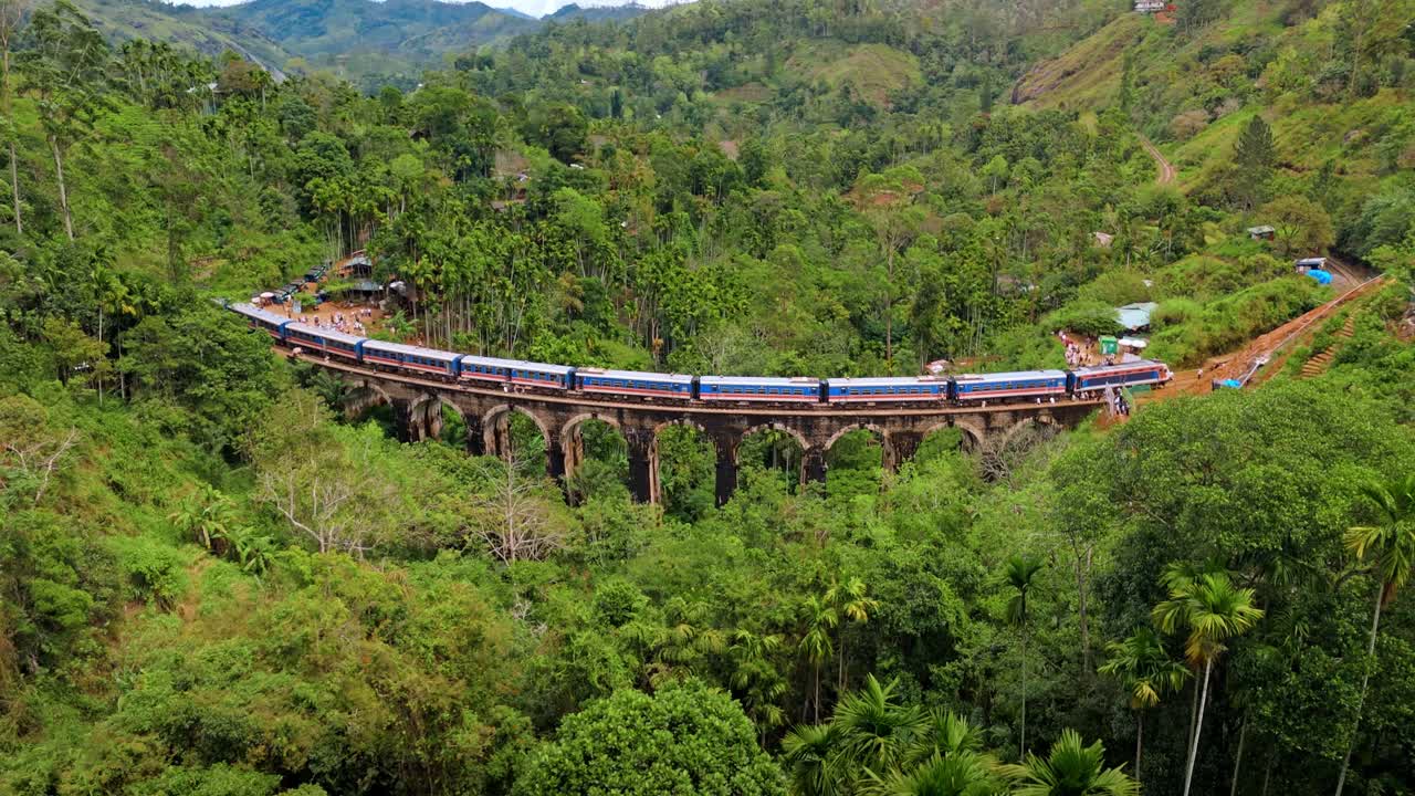 Splendide riprese aeree con drone di un treno che attraversa l'iconico Ponte dei Nove Archi a Ella, Sri Lanka.