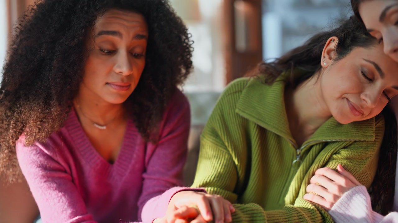 Supportive friends consoling woman sitting home sofa closeup. Multiracial ladies