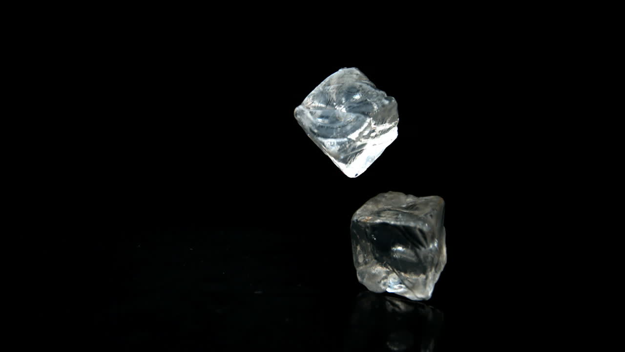 cubos de hielo cayendo y rebotando sobre un fondo negro