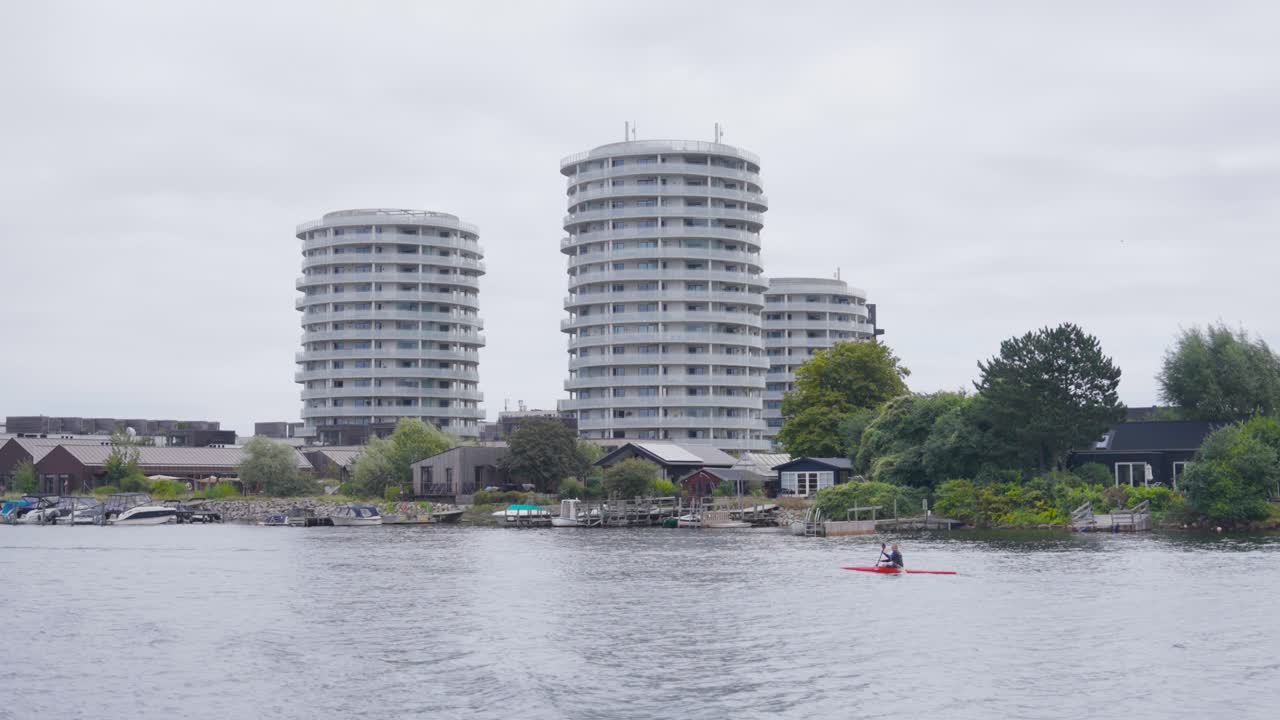 Person in canoe like boat paddle in city river canal, Copenhagen, Denmark
