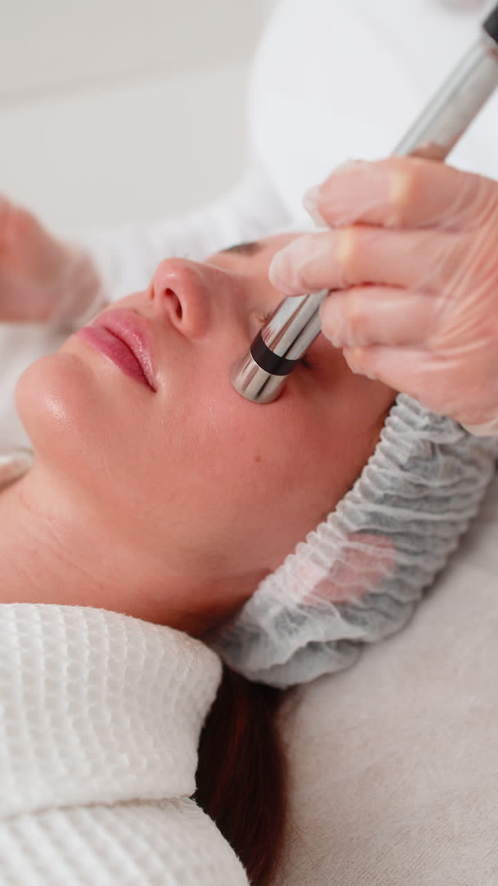 Mesoterapia senza iniezioni o elettroporazione estetista fa la terapia del viso della donna nel salone della clinica