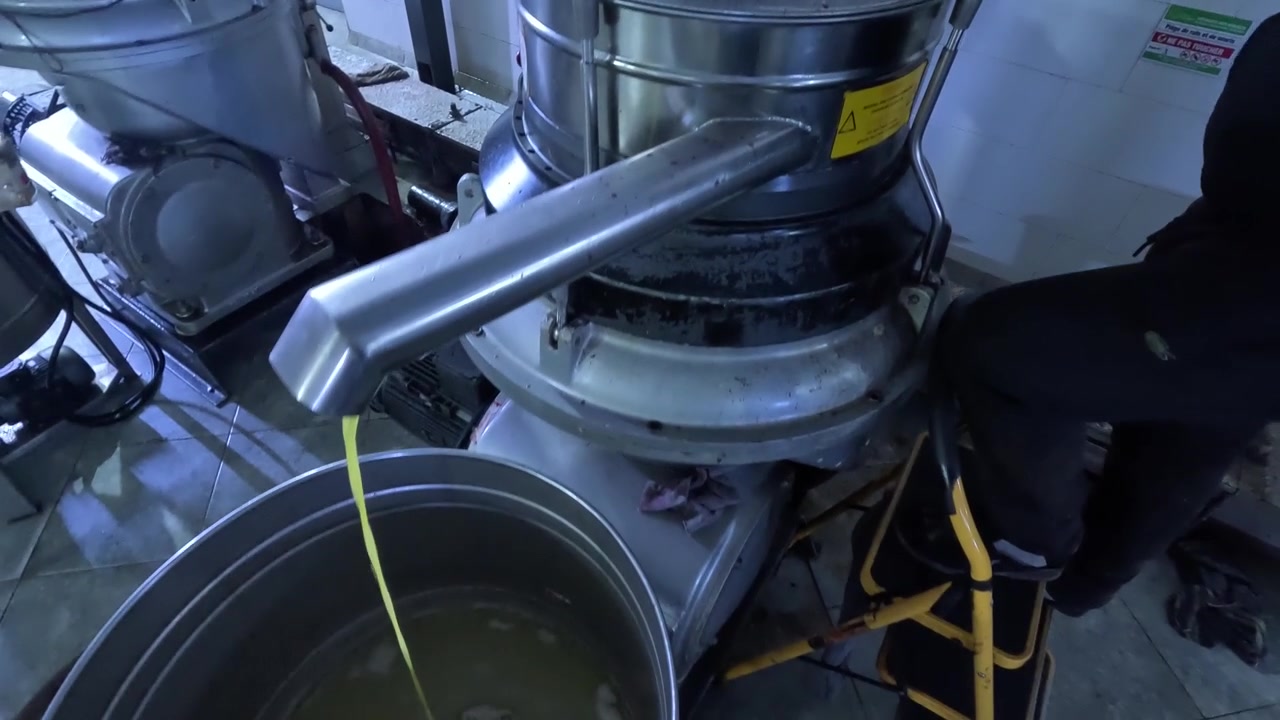Olive paste mixed with process water is fed into a centrifugal separator, where olive oil, vegetation water, and olive pomace are continuously separated by centrifugal force.