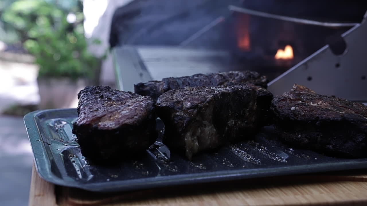 grueso y jugoso filet mignon filetes fumando en la parrilla al aire libre en el patio trasero, cerca de la profundidad poco profunda del campo