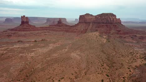 monument valley navajo tribal park, red sandstone butte formations and desert, cinematic aerial view