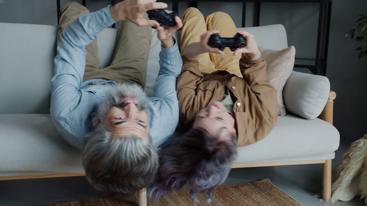 Elderly Couple Playing Video Games on a Couch