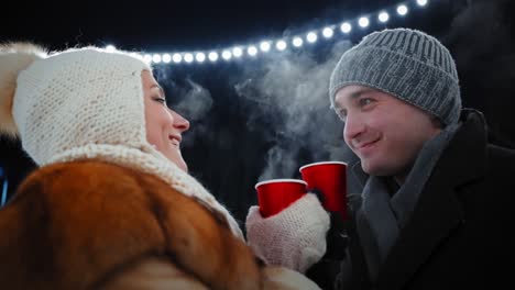 couple enjoying hot drinks outdoors at night
