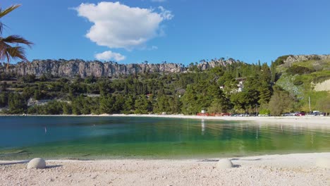 Una-Captura-Inspiradora-De-Una-Costa,-Subrayada-Por-Una-Perspectiva-Pintoresca-De-Una-Cadena-Montañosa,-Que-Realmente-Brilla-Bajo-La-Brillante-Luz-De-Un-Día-Soleado.