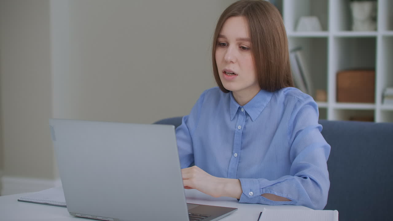 Focused business woman entrepreneur typing on laptop doing research. Young female professional using computer sitting at home office desk. Busy worker freelancer working on modern tech notebook device