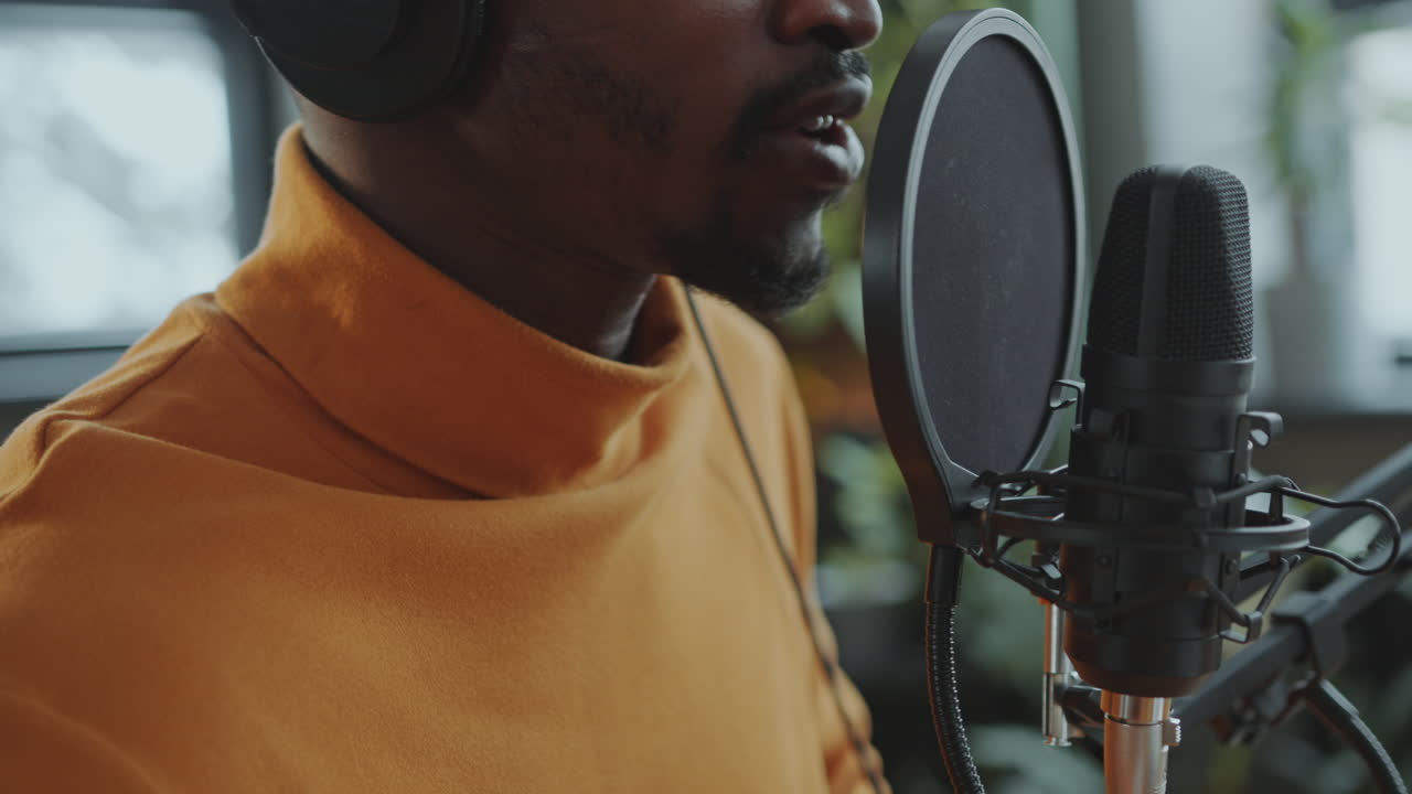 primer plano de un hombre hablando en el micrófono mientras graba un podcast en el estudio