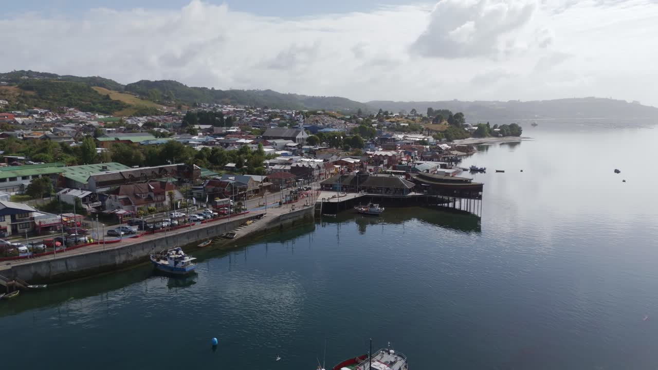 Aerial view of Dalcahue, Chiloe Island, Chile, featuring the waterfront, boats, and the characteristic palafitos