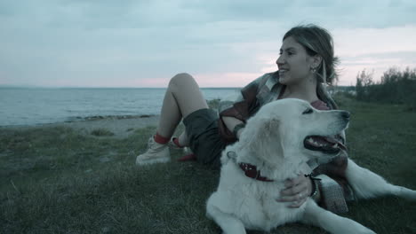 mujer acariciando al perro al aire libre por la noche