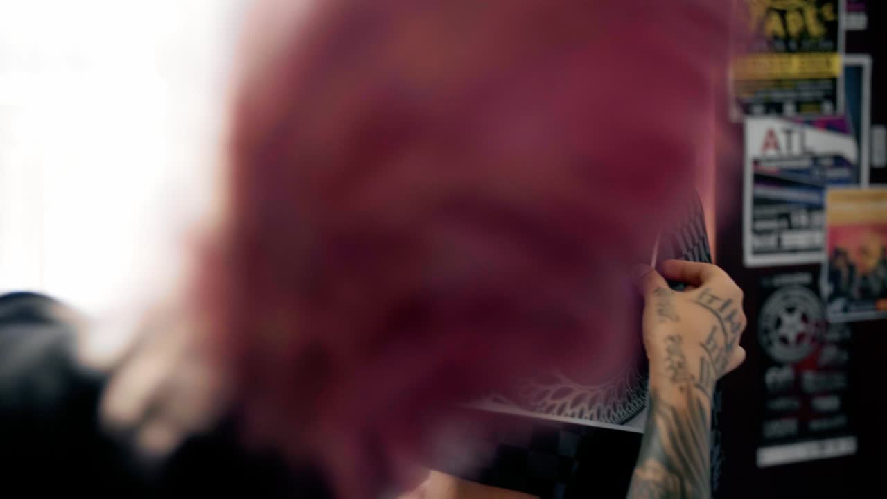 el artista del tatuaje intenta un boceto en el hombro del cliente.