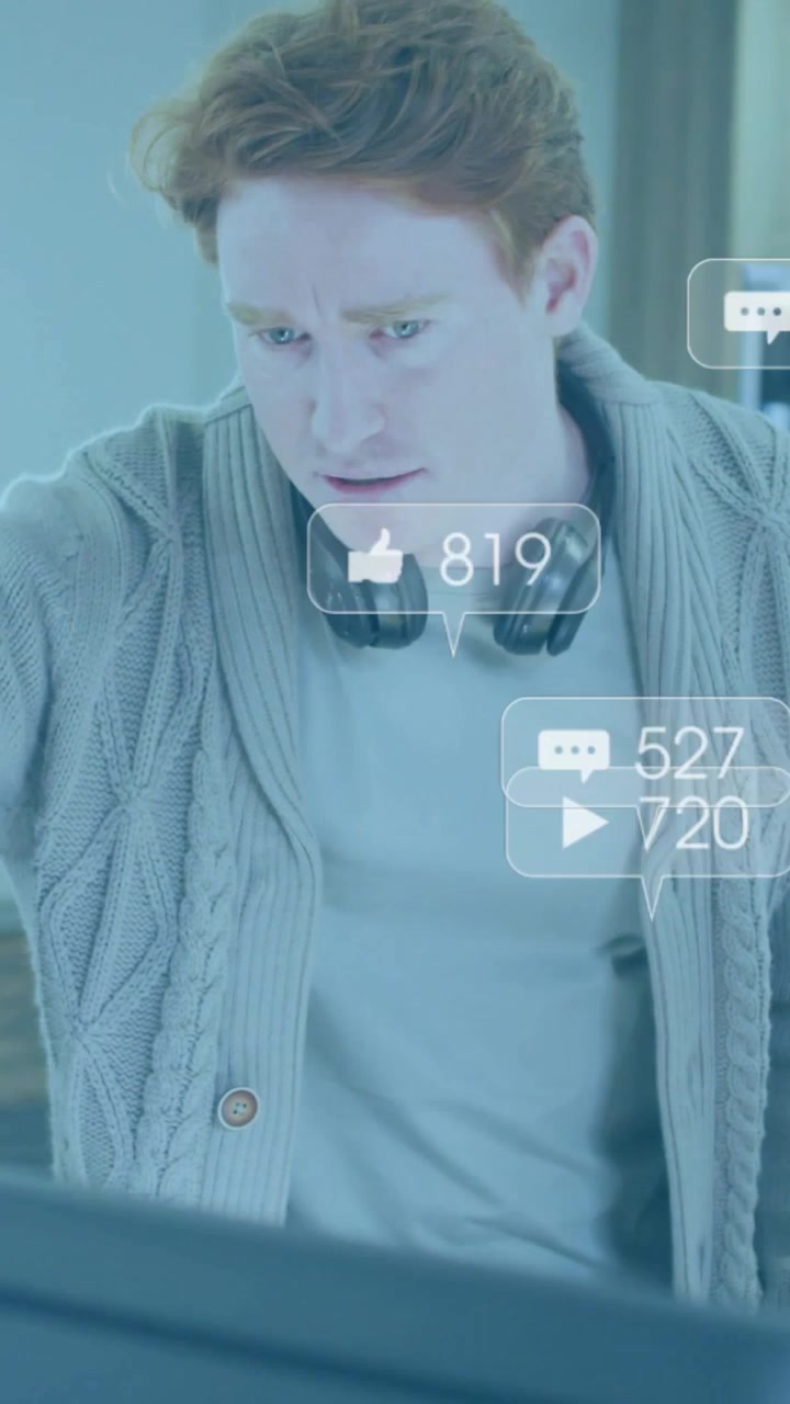 Vertical video: Man leaning over PC, reading popping notifications and monitoring social metrics