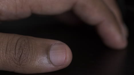 thumb of ethnic minority adult male tapping on desk