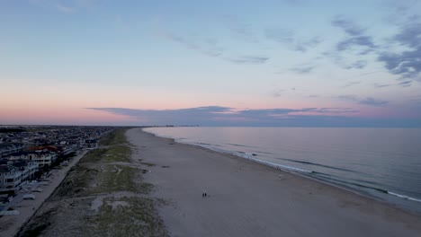 Luftaufnahme-Von-Einer-Drohne,-Die-In-Der-Abenddämmerung-über-Einer-Ozeanstadt,-Dem-Strand-Von-New-Jersey,-Fliegt