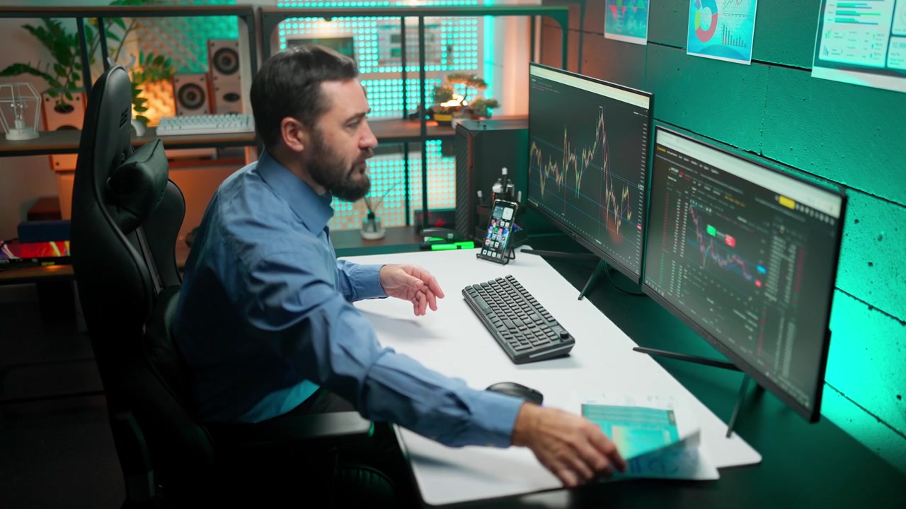 Professional Man Analyzing Financial Data on Computer Monitors