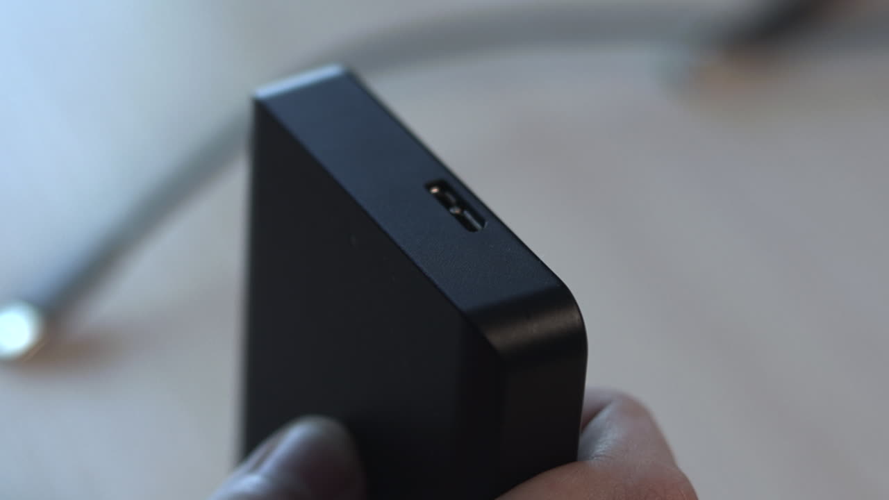 Inspecting Usb Port On Compact Hub Closeup Of Product Reviewer Examining Black Device With Usb Slot, Steady
