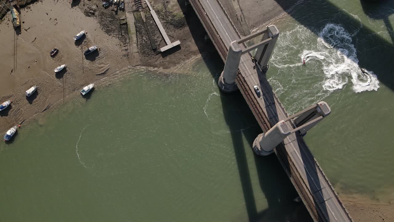 vista superior de los autos que cruzan el puente kingsferry y las carreras de jetski en el canal swale en inglaterra