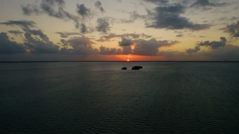 drone shot flying over cancun's tropical waters towards the sunset