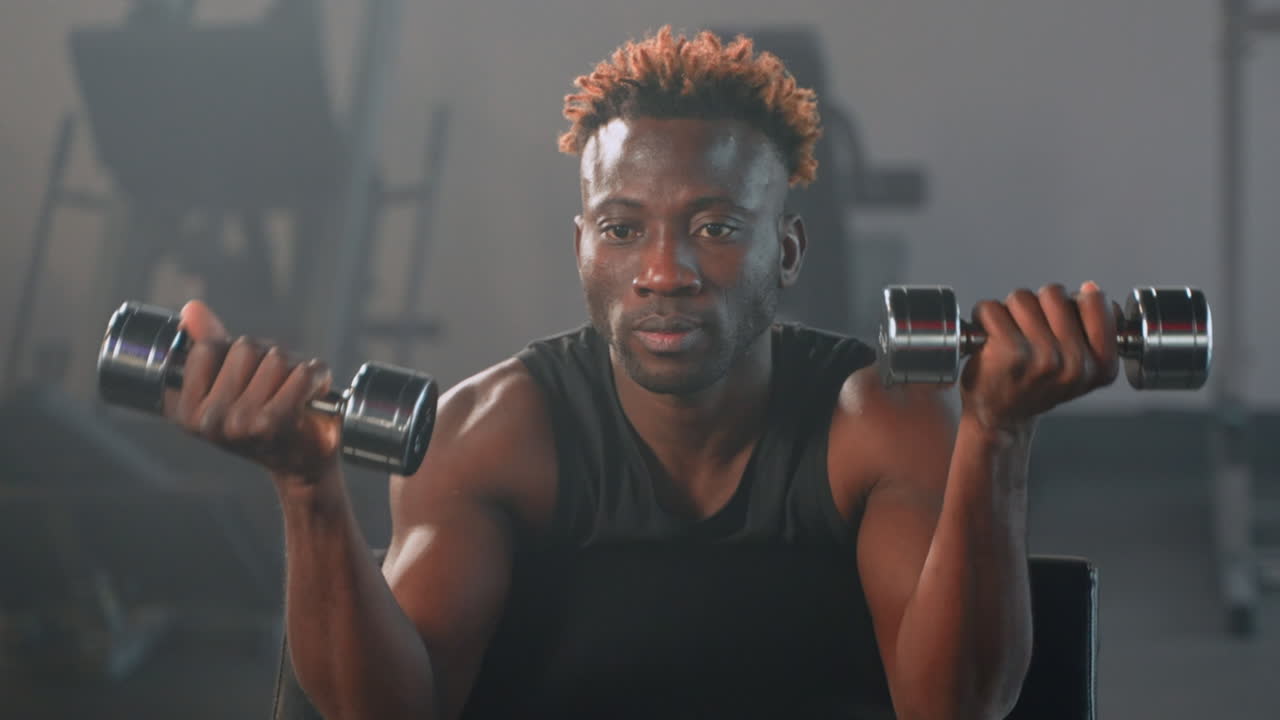 Uomo che si esercita con i dumbbells