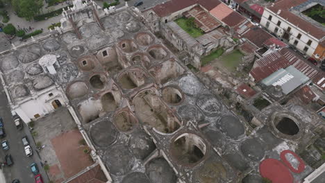 Aerial-footage-of-the-crumbling-empty-roof-of-a-cathedral-next-to-the-main-plaza-in-Antigua,-Guatemala