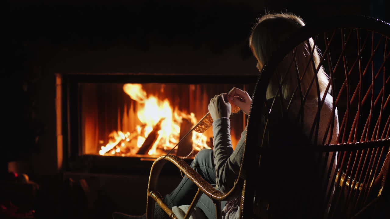 벽난로 겨울 레저 옆에 앉아 바느질을 하는 여자