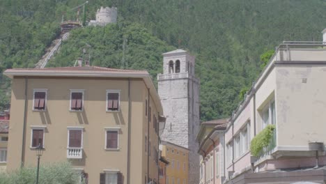 toma de larga distancia de un antiguo campanario en el centro de riva del garda en el norte de italia con montañas en el fondo