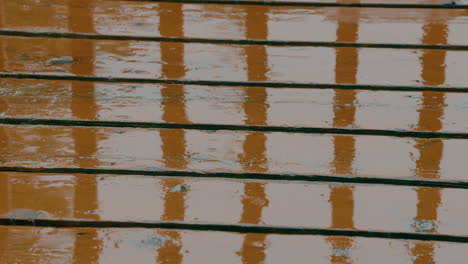 rain drops splashing on to a wood deck during a light shower