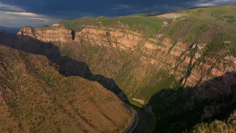 glenwood canyon scenic drive i70 glenwood springs colorado river aerial drone summer traffic sun grand mesa cliffside flat top hanging lake late afternoon dark rain thunderstorm cloudy forward pan up