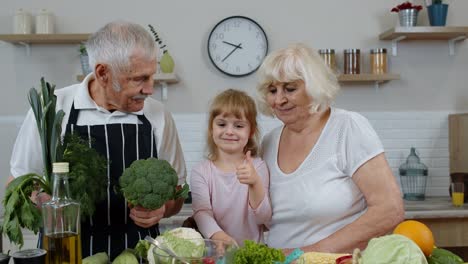 grandchild girl with senior grandparents recommending eating raw vegetable food. nutrition diet