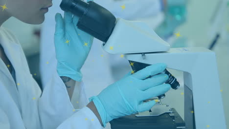 animation of dots floating over biracial female lab worker using microscope