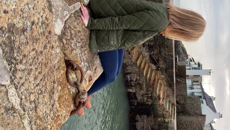 hermosa joven sentada en el puerto irlandés sonriendo