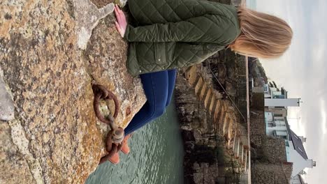 beautiful young woman sitting on irish harbour smiling