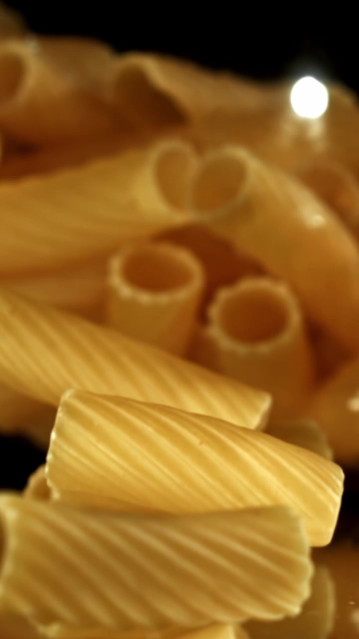 Primo piano di rigatoni secchi che cadono al rallentatore