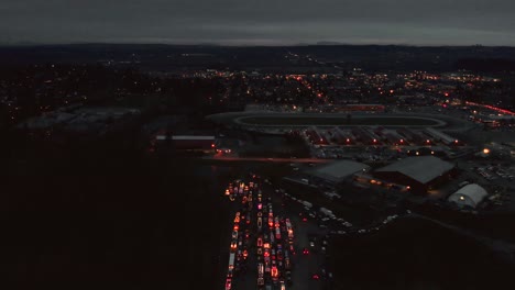 drone 4k footage cloverdale christmas parade flying backward at haunting night revealing the city in the distance where cars and trucks in a traffic jam